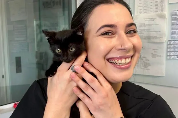 Veterinária da UNISA com um gatinho preto no colo